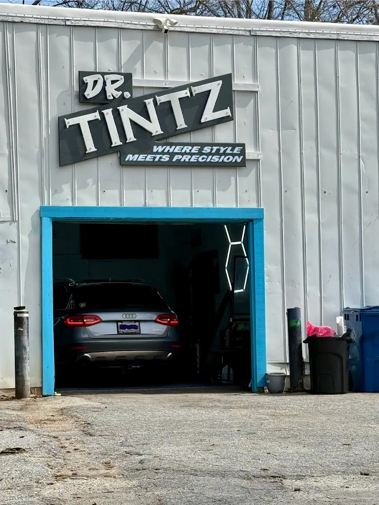 The Doctor Tintz shop front with its signature blue garage door and 'Where Style Meets Precision' sign